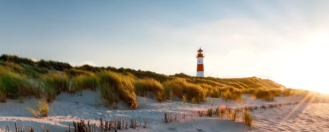 Düne auf Sylt mit Leuchtturm und Sonnenuntergang