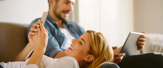 Familienabo: zwei Personen lesen die digitale Tageszeitung auf Tablet und Smartphone