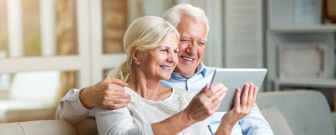 Mann und Frau lesen die Zeitung auf einem Tablet